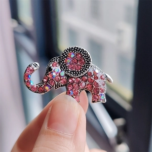 Detail of a silver elephant brooch with pink rhinestones held in hand for size