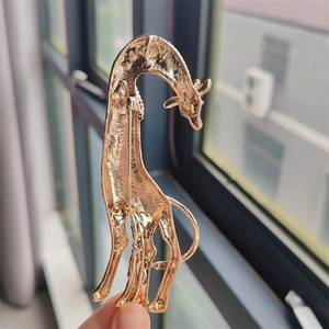 Detailed back view of a giraffe brooch with gold-plated alloy texture and safety pin clasp