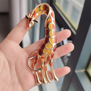 Handheld giraffe brooch with colorful enamel spots and gold-tone finish details