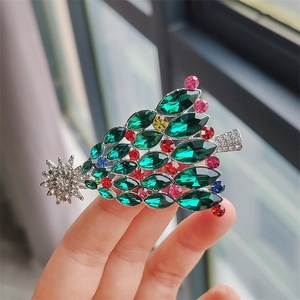 Vue rapprochée d'une broche sapin de Noël argentée sertie de strass colorés