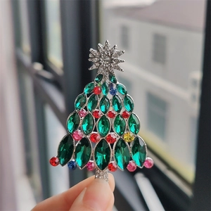 Détail d'une broche sapin de Noël en argent avec cristaux verts et strass multicolores