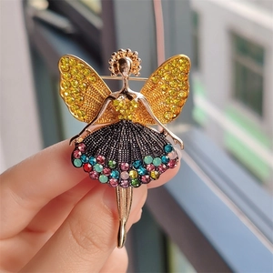 Detailaufnahme einer goldenen Ballerina-Brosche mit bunten Kristallen und Strass