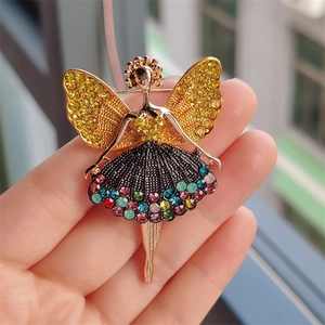Brosche in Form einer Ballerina aus goldener Legierung mit bunten Strasssteinen in der Hand