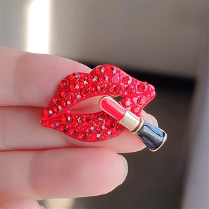 Close-up of red rhinestone lipstick lip brooch showcasing hand-held size and details