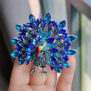 Detailed view of peacock brooch featuring blue crystals and shimmering rhinestones