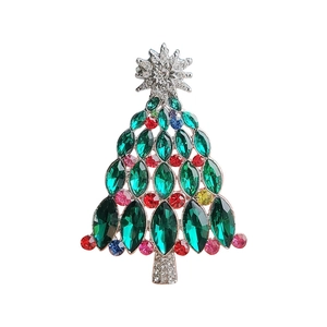 Broche sapin de Noël avec cristaux verts et strass colorés sur une base en métal