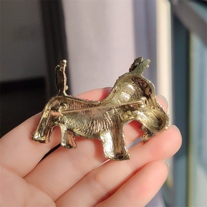 Detail view of the back of the vintage gold metal dog brooch showing the pin clasp