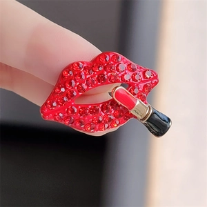 Close-up of sparkling red rhinestone lips brooch with a miniature lipstick detail