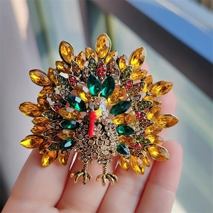 Vintage turkey brooch with colorful rhinestones for Thanksgiving shown held by a hand