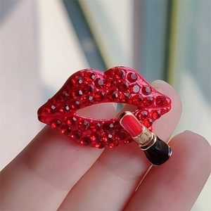 Macro shot of red crystal encrusted lips brooch with a miniature lipstick detail