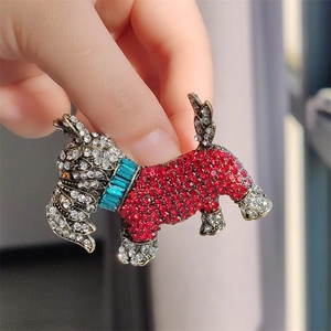 Detail of Scottish Terrier brooch with red and white crystals held by a person