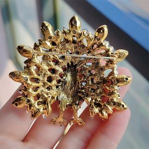 Close-up of golden turkey brooch back side with pin closure and intricate feather textures