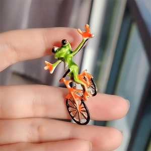 Creative green frog riding an orange bicycle enamel brooch for suits and coats