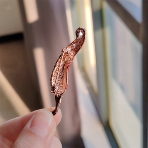 Détail macro du dos de la broche piment en placage or rose avec fermoir de sécurité