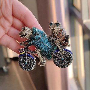 Vintage style frog prince on motorcycle brooch featuring colorful rhinestones