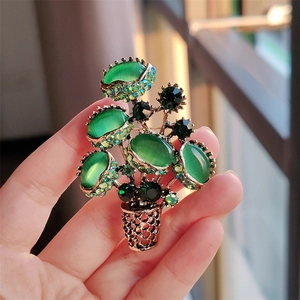 Luxurious green opal plant brooch with sparkling rhinestones in a gold flowerpot design