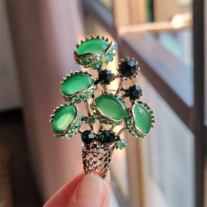 Detail of vintage flower bouquet brooch with green cat-eye stones and rhinestones