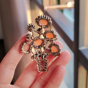 Back view of a vintage sunflower basket brooch with amber cat eye stone and pin detail