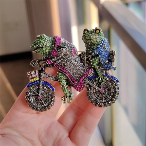 Detailed close-up of a vintage style frog on motorcycle brooch with colorful rhinestones