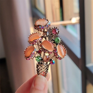 Close-up of a floral bouquet brooch with opal-like stones and colorful rhinestones