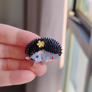 Broche hérisson en émail mignon avec fleur jaune et finition en métal doré