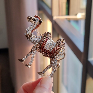 Exotic camel brooch with white crystals and colorful enamel on a golden alloy base