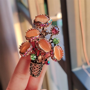 Macro view of vintage flower brooch with orange cat-eye stones and colorful rhinestones