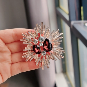 Macro detail of starburst brooch with red pear-cut stones and sparkling crystals