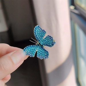 Macro shot of butterfly brooch with blue crystals and silver metallic edges