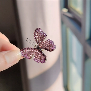 Close-up of butterfly brooch with purple and pink gradient crystals in macro detail