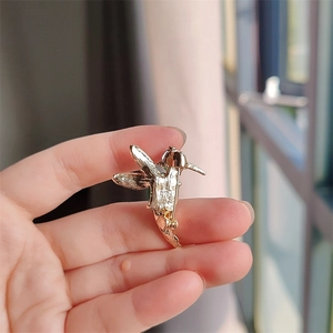 Detailed back view of a gold hummingbird brooch showing the pin fastening mechanism