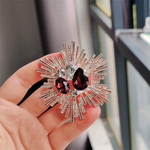 Detail of vintage sunburst brooch featuring purple crystals and gold plated rays