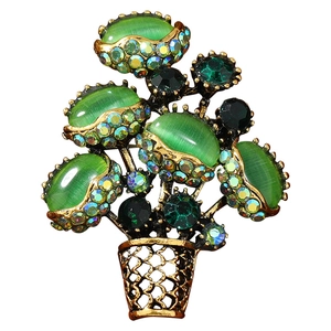 Luxurious bouquet brooch with green cat-eye stones and sparkling crystals in gold setting