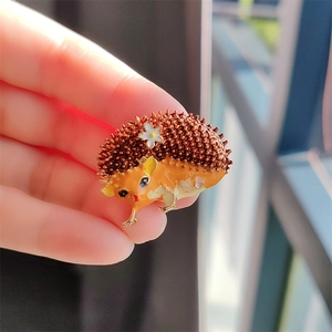 Broche hérisson mignonne en émail avec petite marguerite blanche et détails jaunes