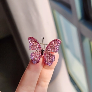 Macro shot of butterfly brooch with pink and purple gradient crystal pavé detailing
