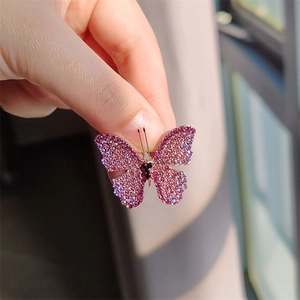 Detailed close-up of a butterfly brooch featuring pink and purple gradient rhinestones