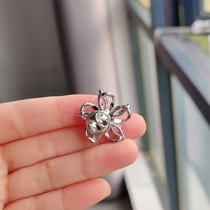 Macro view of the silver-tone five-petal flower brooch back with butterfly clasp