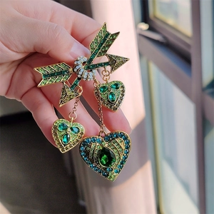 Broche flèche de Cupidon vintage avec pierres vertes émeraude et cœurs suspendus dorés