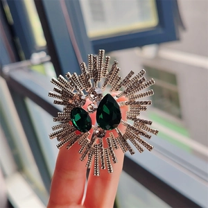 Vintage sunburst brooch with green crystal stones and gray rhinestones on alloy