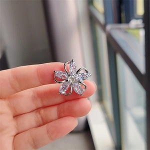 Macro shot of silver flower brooch featuring marquise zircon petals and center gem