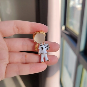 Détail d'une broche infirmière en dessin animé avec émail doré et pierre précieuse