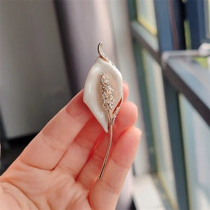 Elegant Calla Lily brooch in gold and ivory white with shimmering crystal inlay