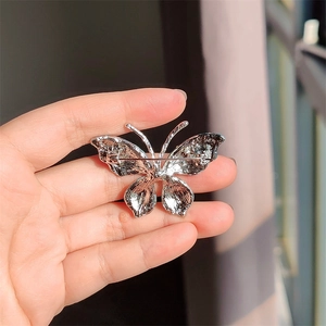 Detailweergave van de zilveren vlinderbroche achterkant met de stevige veiligheidsspeld