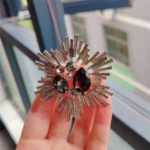 Detailed shot of a vintage starburst brooch with purple teardrop crystal and golden rays