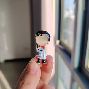 Détail d'une mignonne broche docteur en émail avec visage en opale et blouse blanche