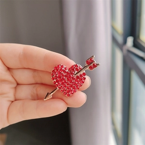 Vue détaillée de la broche cœur flèche de Cupidon avec strass rouges et dorure