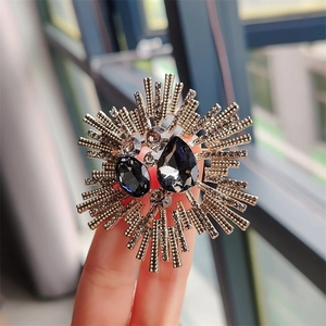 Vintage sunburst crystal brooch featuring grey teardrop stones in a retro metal setting