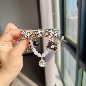 Broche élégante en tweed avec bouton perle, chaîne dorée et breloque tour Eiffel pour femme