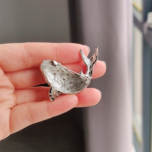 Dettaglio del retro della spilla a balena d'argento con chiusura a spillo e strass
