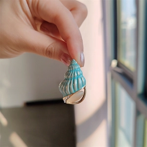 Spilla a conchiglia creativa con smalto blu e intarsio di opale su base dorata